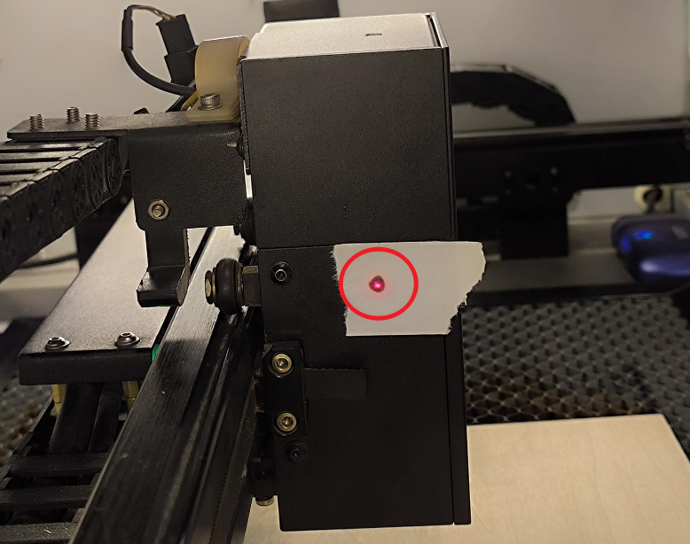 Red dot aligned to overlap with laser burn mark