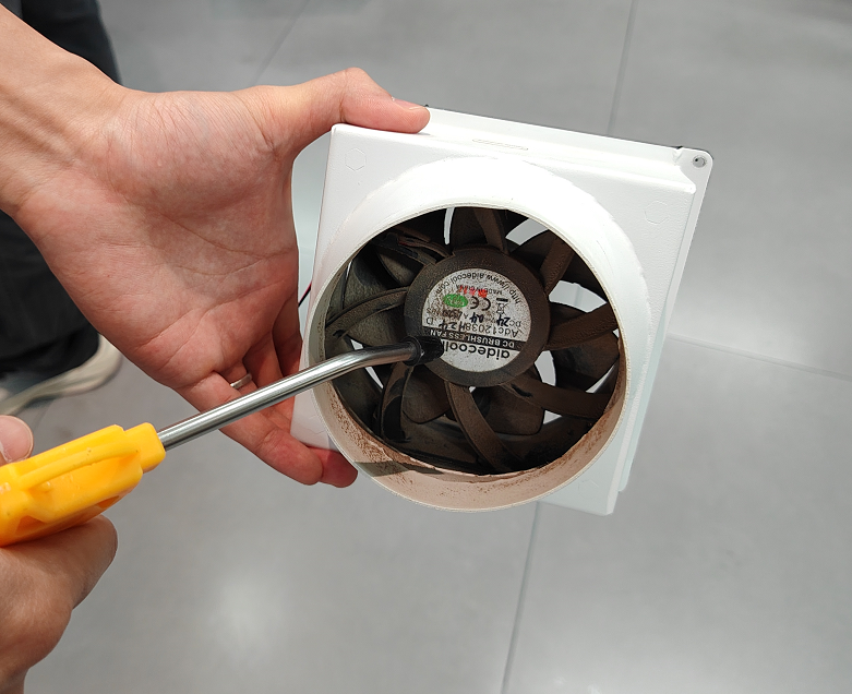 Cleaning dust from X Series exhaust fan blades with an air gun